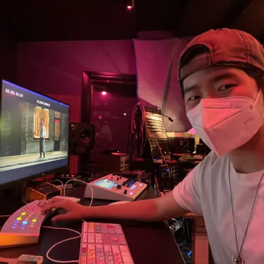  Elie Ziehl, wearing a mask, at a keyboard and screen, bathed in red light