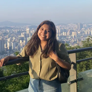 Zia Smith smiling with a city scape visible in the distance behind