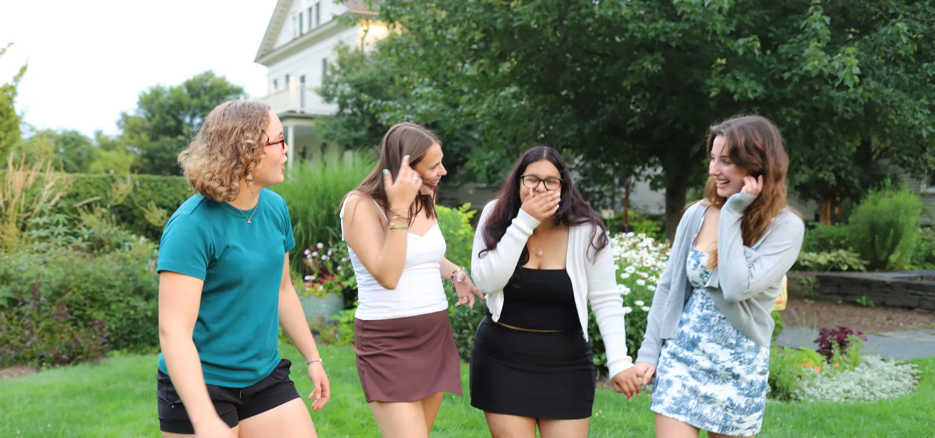 Four Precollege students laughing together.