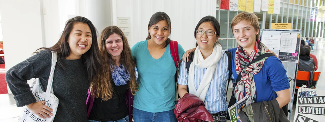 A group of smiling students posing in the Campus Center