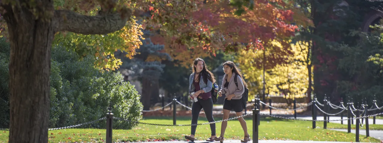 Two students walking down a campus path.