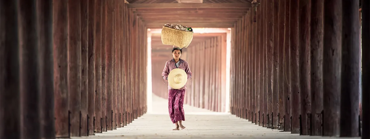 Photo of a woman carrying a basket on her head