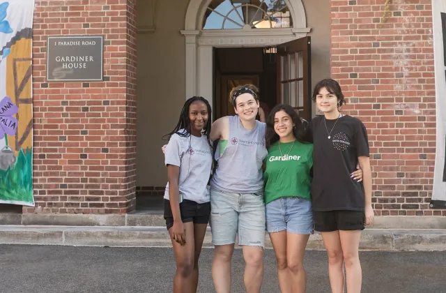 Four students standing in front of Gardiner House.