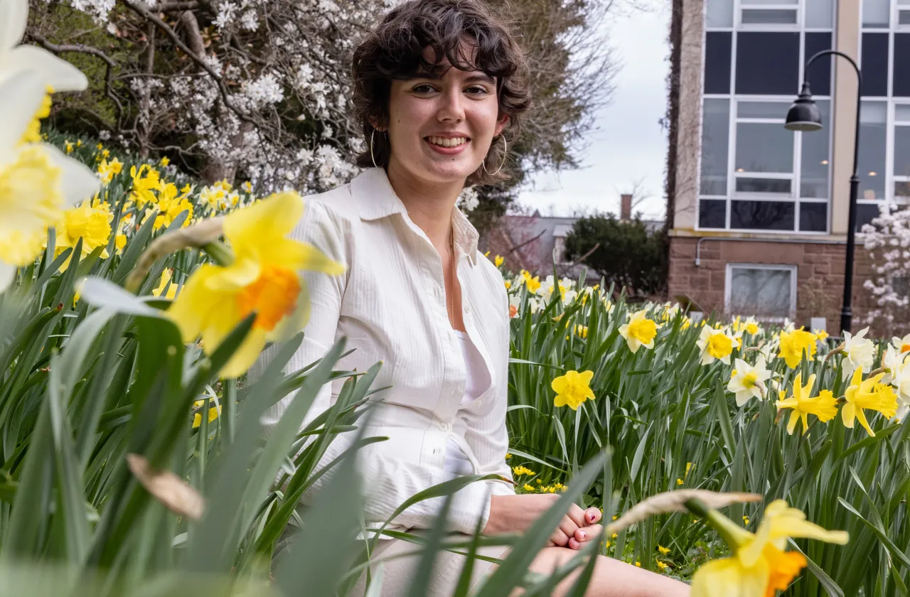 Gabriela Eastwood sitting among daffodils at Smith College.