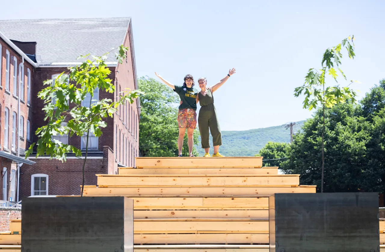 Jess Gersony and Amanda Lovelee stand atop the bleachers in between the two newly planted oak trees.