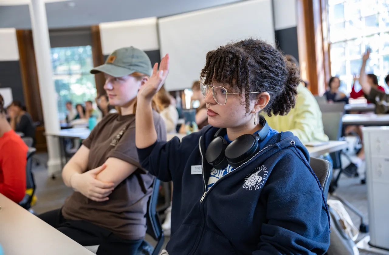 A student raising their hand in class.
