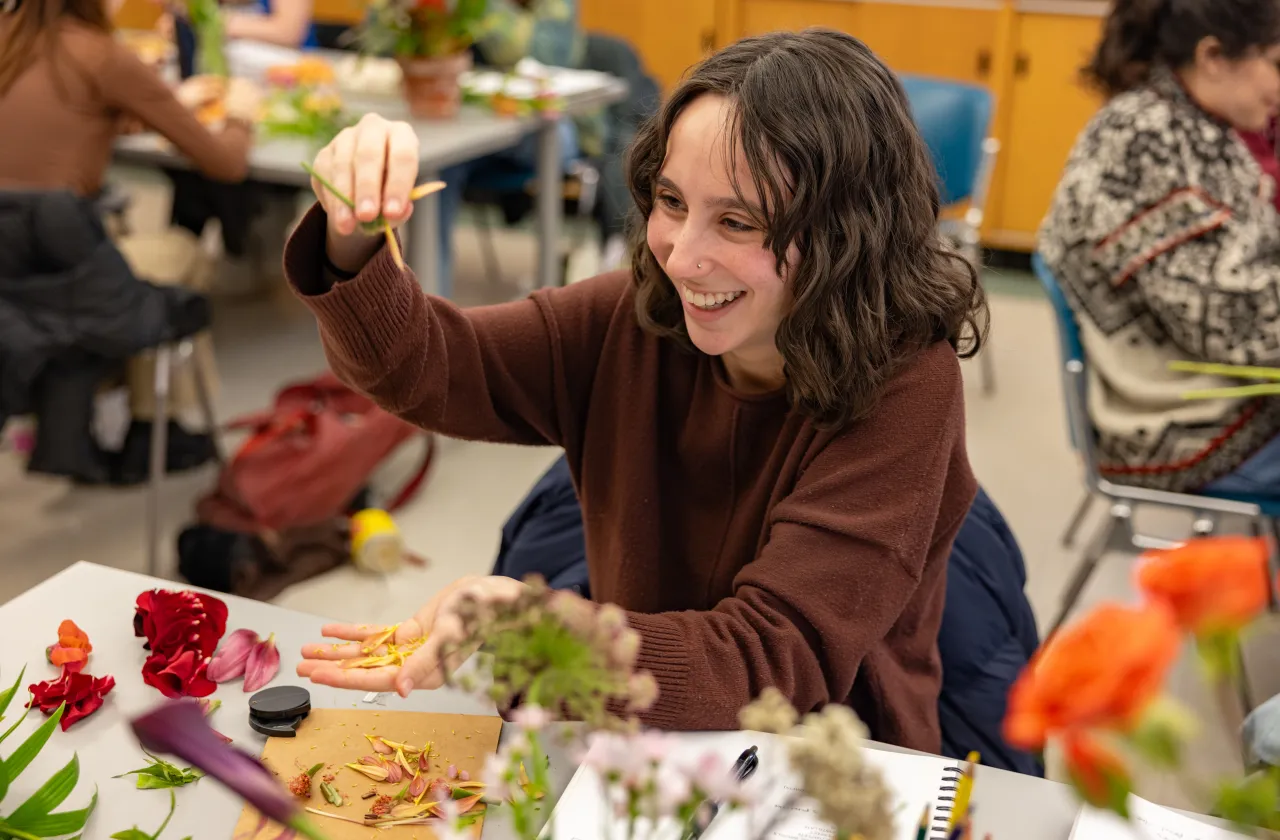 A student in a botany class examines flower petals.
