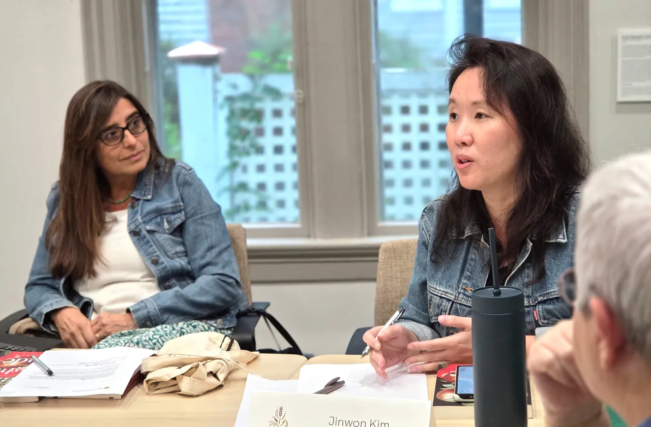 Jinwon Kim speaking during a seminar, seated next to a name card reading "Jinwon Kim, Sociology."