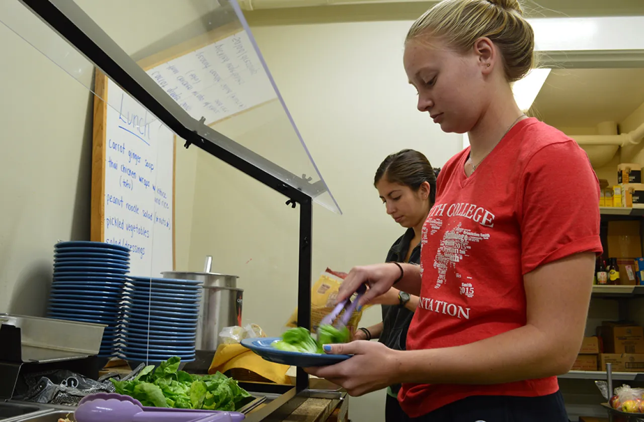 Two students make selections from a buffet