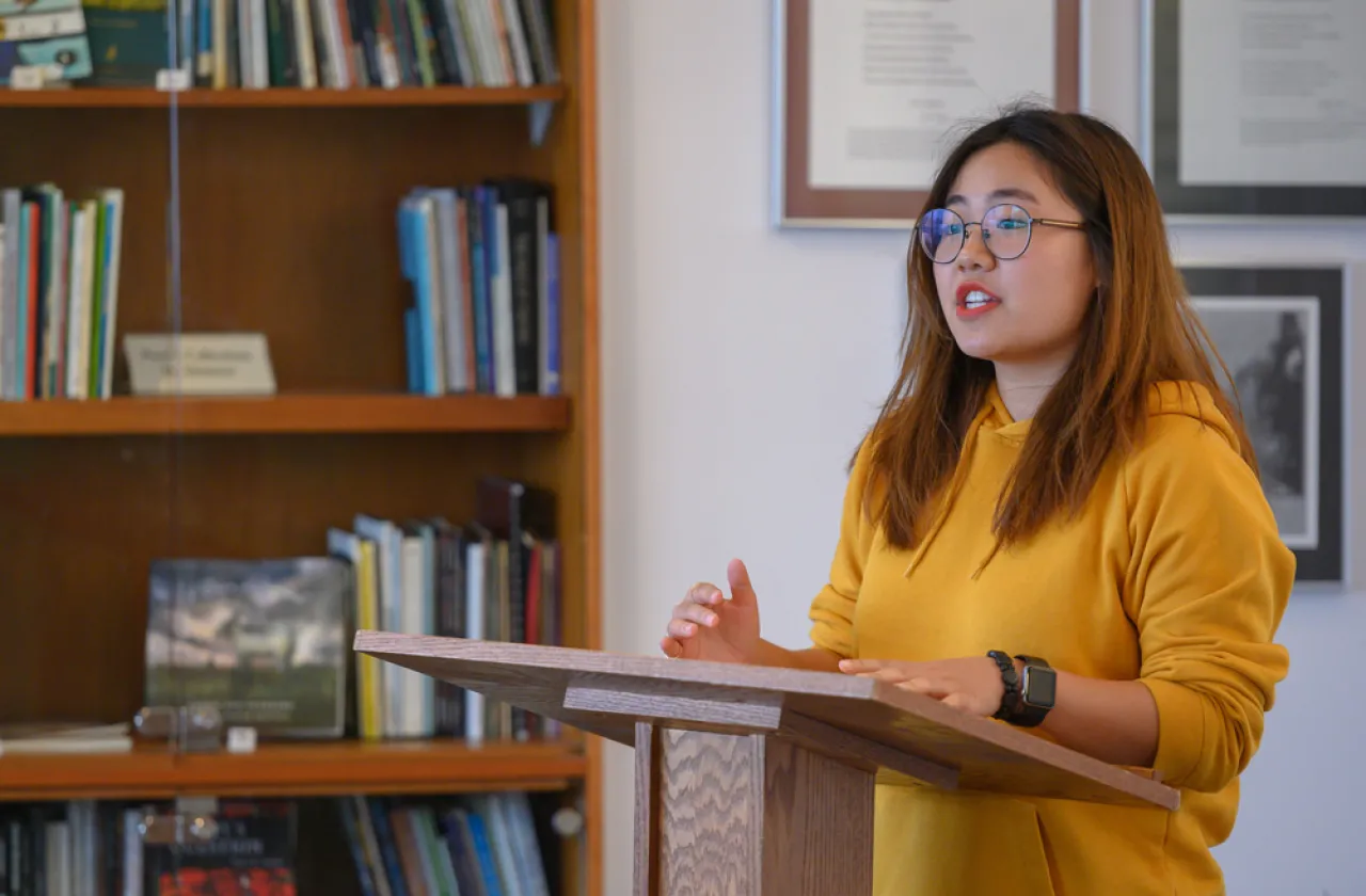 A student reading a poem at a podium