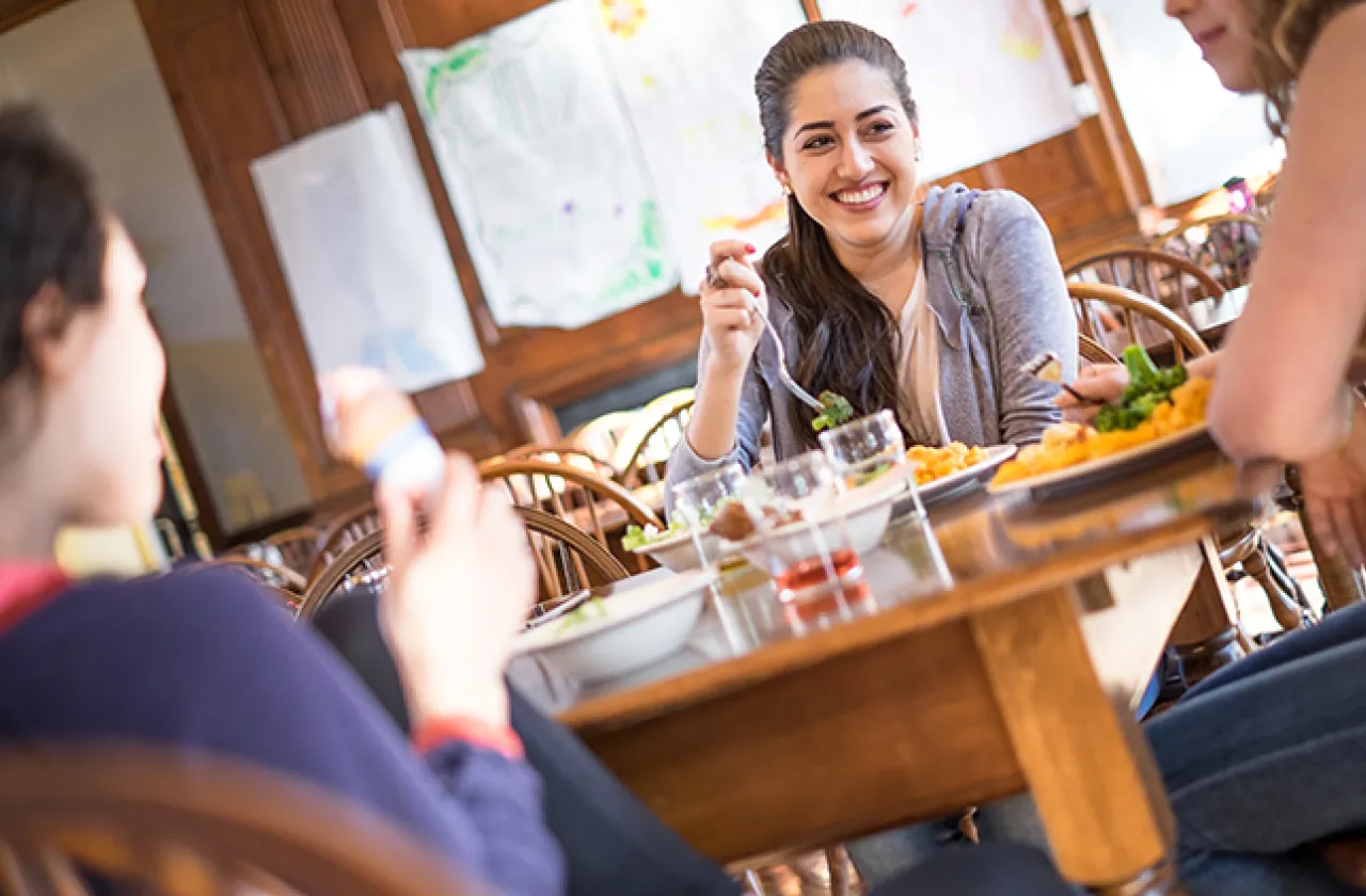 Three students gathered around a table for lunch