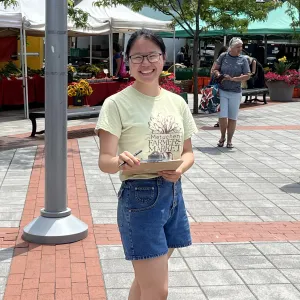 Erica Li at the farmer's market holding a clipboard.