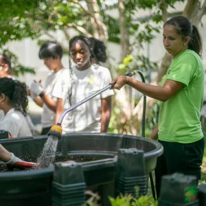 FAO Schwarz Fellow Julia Beyer '26 (at right) helps teens at an outdoor plant sale 