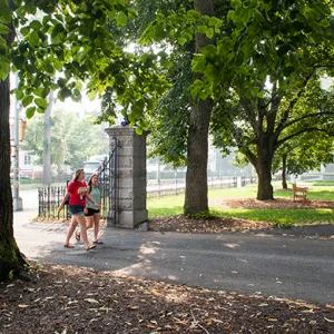 Two students walking through the entry gate to campus