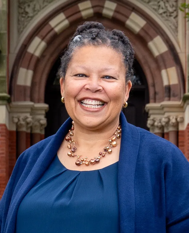 Sarah Willie-LeBreton smiling outdoors in front of College Hall. Square cropped photo, close-up.