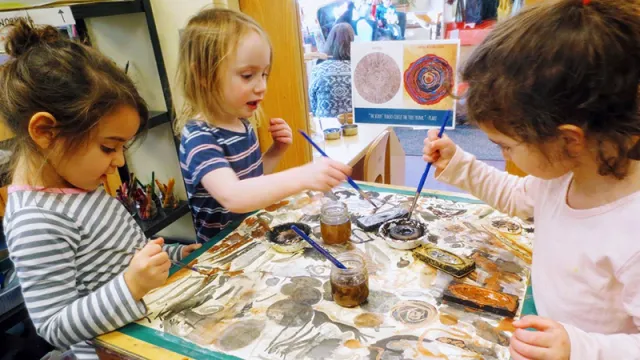 Three girls painting on a table top