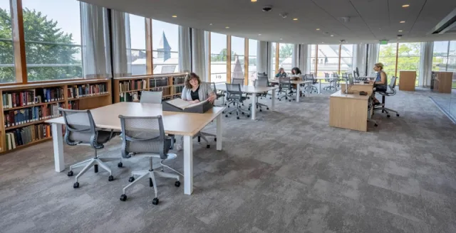 Room with wrap around windows, a low bookcase and big tables