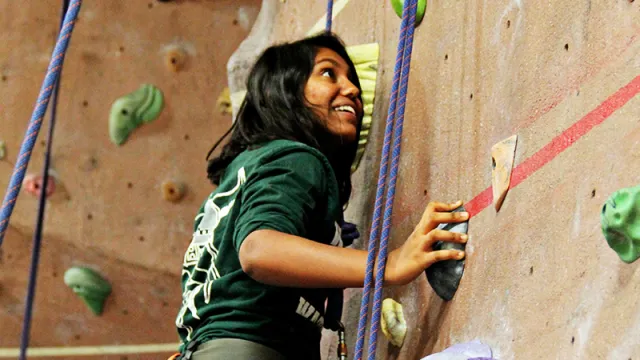 Student climbing a rock wall