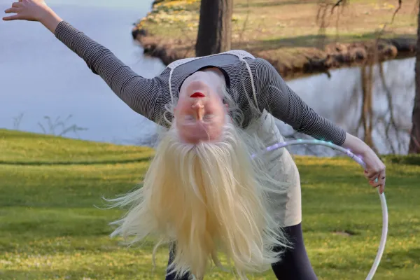 Una Fonte bends backward while holding a white hoop in front of Paradise Pond