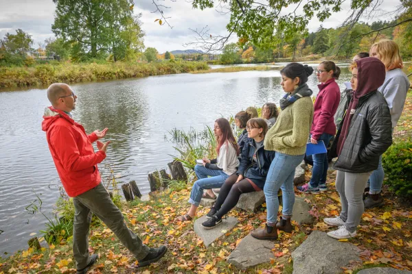 Reid Bertone-Johnson on a river bank teaching students