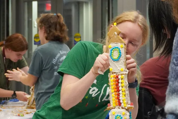 An engineering student puts the final touches on a gingerbread skyscraper