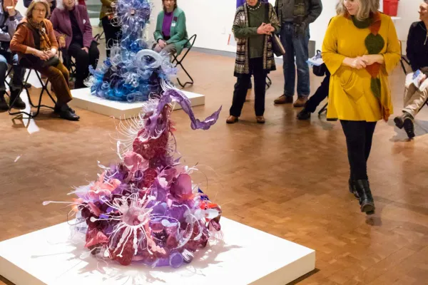 Viewers standing around sculpture by Aurora Robson