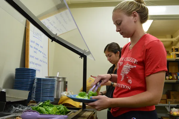 Two students make selections from a buffet