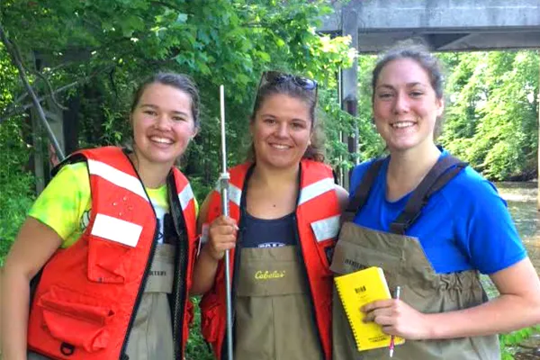 Smith juniors (from left) Emma Harnisch, Sally Cartarr and Lizzie Sturtevant measure water flow in Paradise Pond following a heavy rainfall.