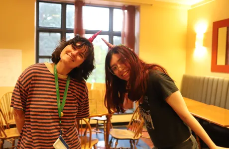 Two students smile while wearing unicorn horns