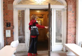 A student opening the door to a Smith house.