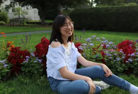 A student smiling in a garden at Smith.