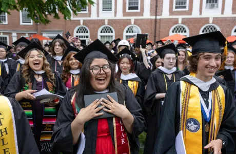 A graduate clutches their diploma after the diploma circle.