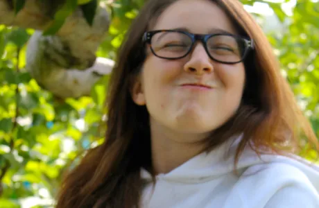 A student smiles holding an apple on Mountain Day in 2014