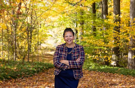 Sarah Willie-LeBreton standing in front of trees in the fall