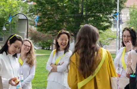 Smithies in white wearing yellow sashes laugh during Reunion