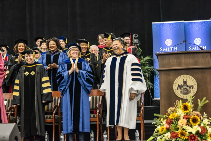 President Sarah Willie-LeBreton standing and smiling next to former Smith College presidents Kathleen McCartney and Carol Christ during the installation ceremony.