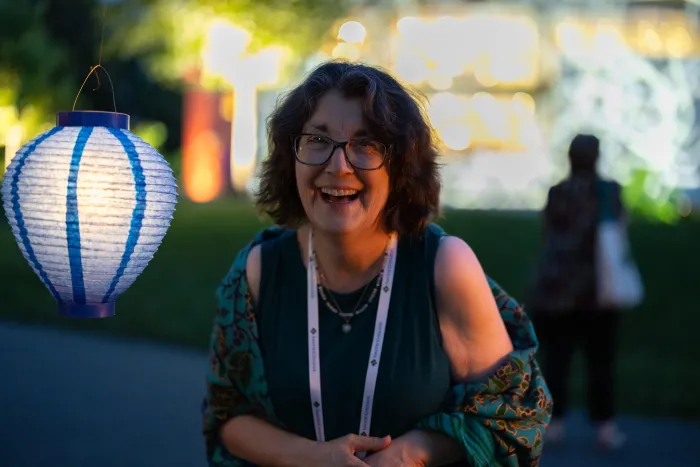 A Smithie smiles in front of a paper lantern during Illumination