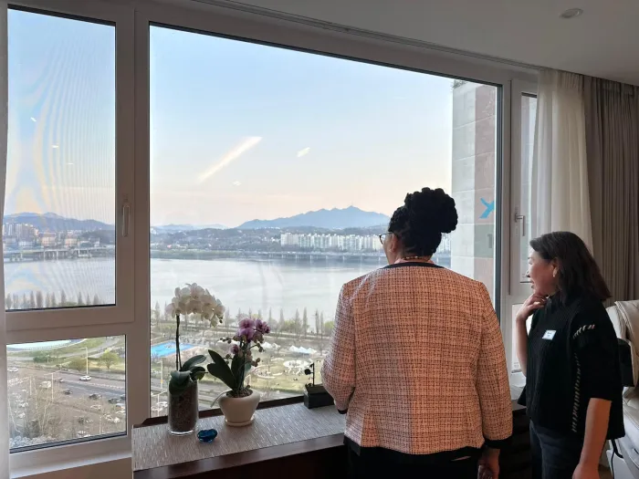 President Sarah Willie LeBreton and Diana Kang '78 look out the window at the Han River in Seoul, South Korea.