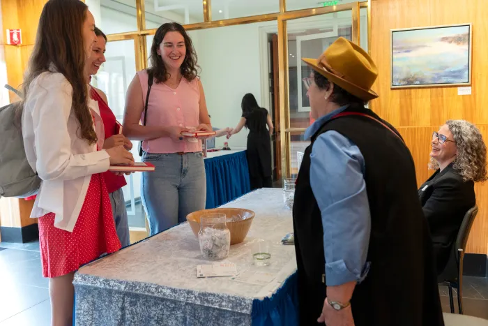 Students smile while receiving information about the Alumnae Association