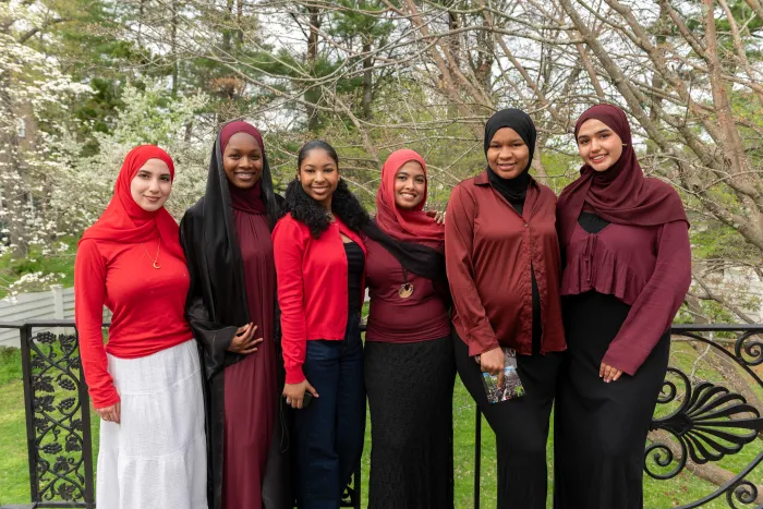 A group of students, all dressed in red, smile at the camera