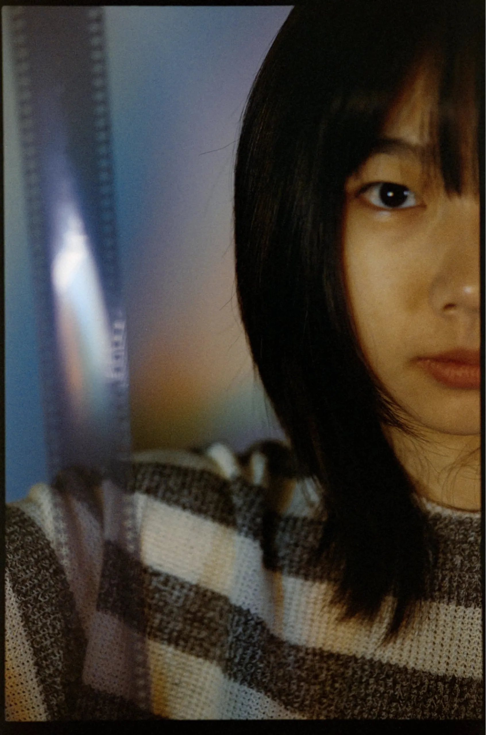 A blank roll of film next to a person's face.