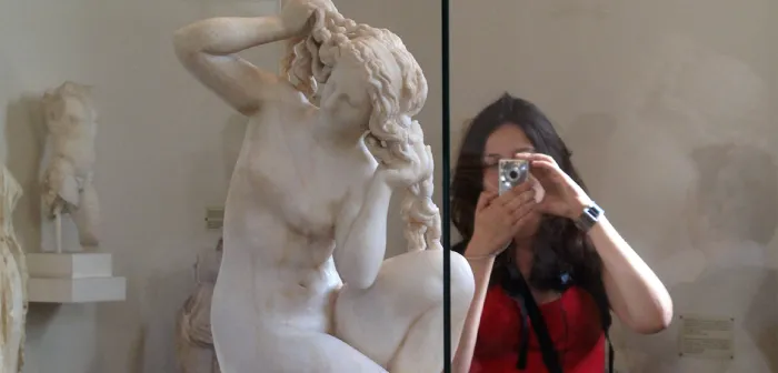 Student taking a photo of Greek statue