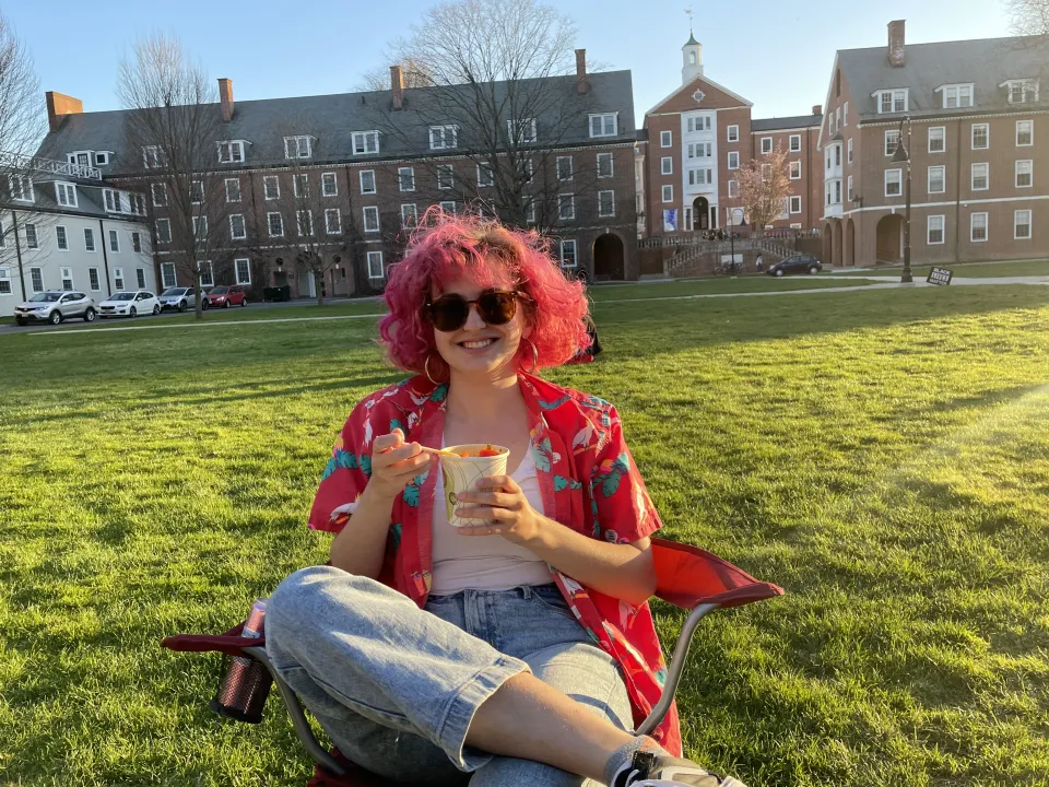 Grayson Hawthorn ‘24 with pink hair in a lawn chair in the quad