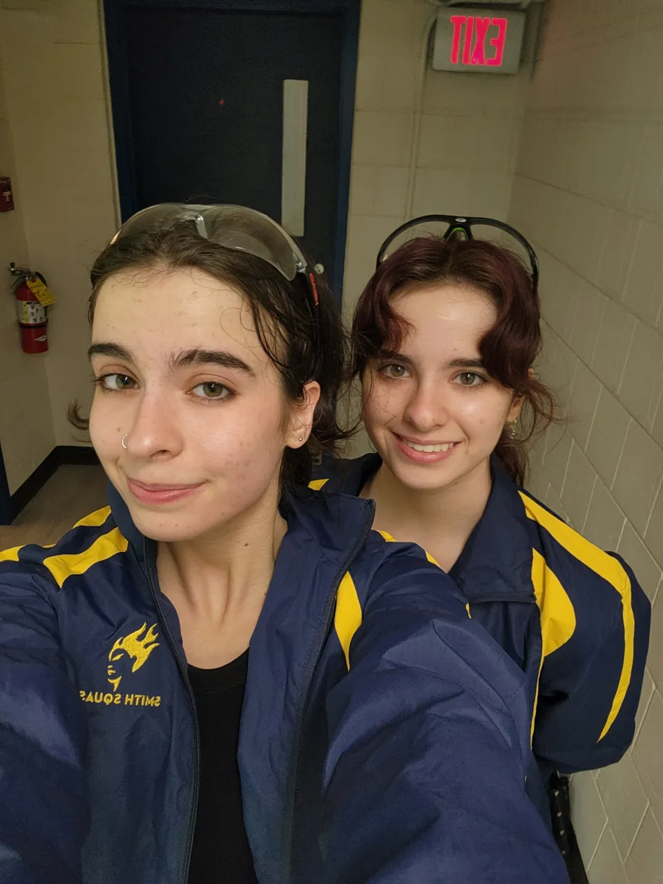 Ciana Socias in a yellow and navy uniform with fellow squash teammate