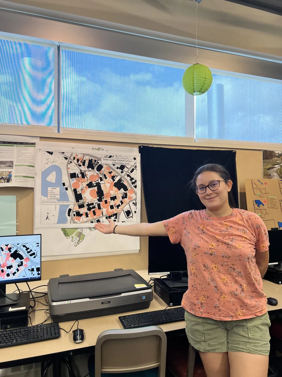 Nermine Mokdad points to architecture drawing in orange and black