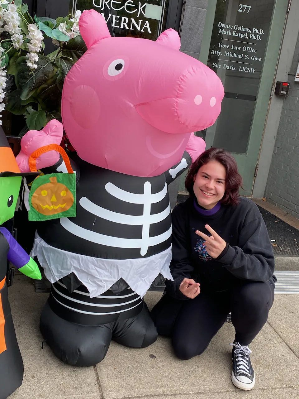 Katherine Booth smiling and posing next to a blow-up Peppa Pig