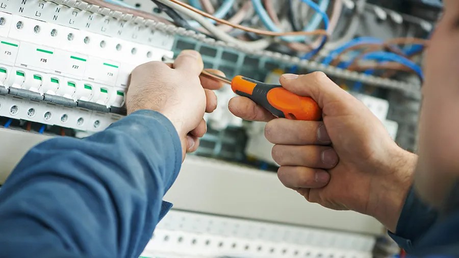 Closeup of an electrician working on an electrical panel