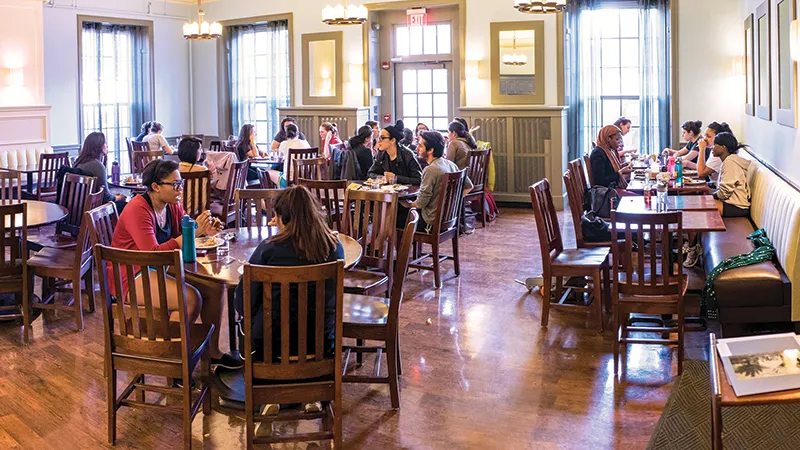 A group of students gathered around a table of snacks
