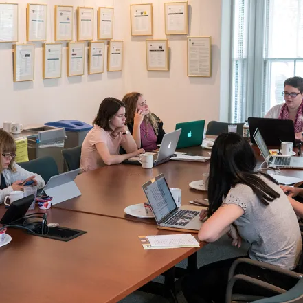 Students gathered around a table in the Kahn colloquium room