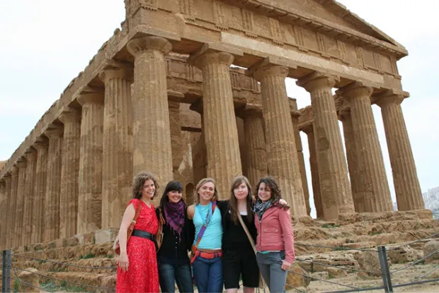 Photo of students posing in front of ancient ruins in Italy
